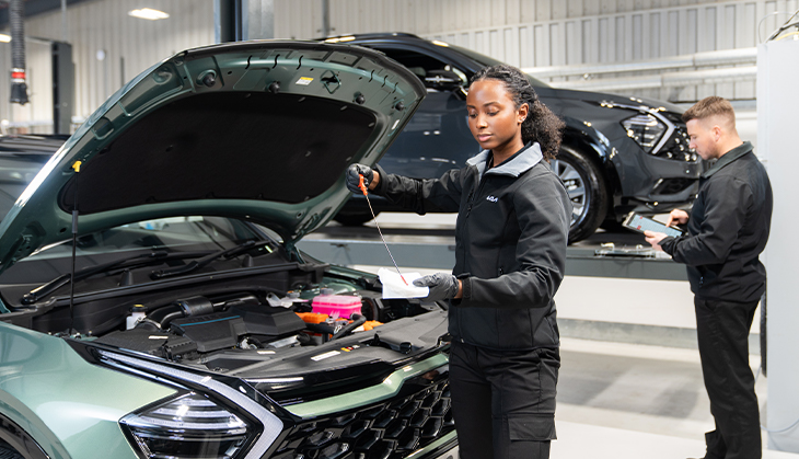 Kia technician providing servicing and maintenance replacements on a Kia car.